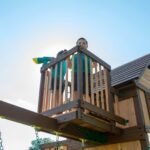 Skyfort II Wooden Backyard Playset & Swing Set with Spiral Tube Slide shown in an outdoor setting