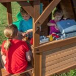 Cedar Cove Wooden Backyard Playset & Swing Set shown in an outdoor setting