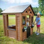 Sweetwater Wooden Kids' Backyard Playhouse shown in an outdoor setting