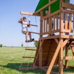 Grayson Peak Wooden Backyard Playset & Swing Set shown in an outdoor setting