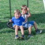 Whispering Point Wooden Backyard Playset & Swing Set shown in an outdoor setting