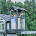 Whispering Point Wooden Backyard Playset & Swing Set shown in an outdoor setting