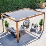 Brendan 12 ft. x 10 ft. Pergola with Sail-Shade Canopy shown in an outdoor setting