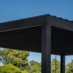 Sarasota 12 ft. x 10 ft. Steel Louvered Patio Pergola shown in an outdoor setting