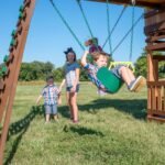Backyard Discovery Woodridge Elite gray playset swings view